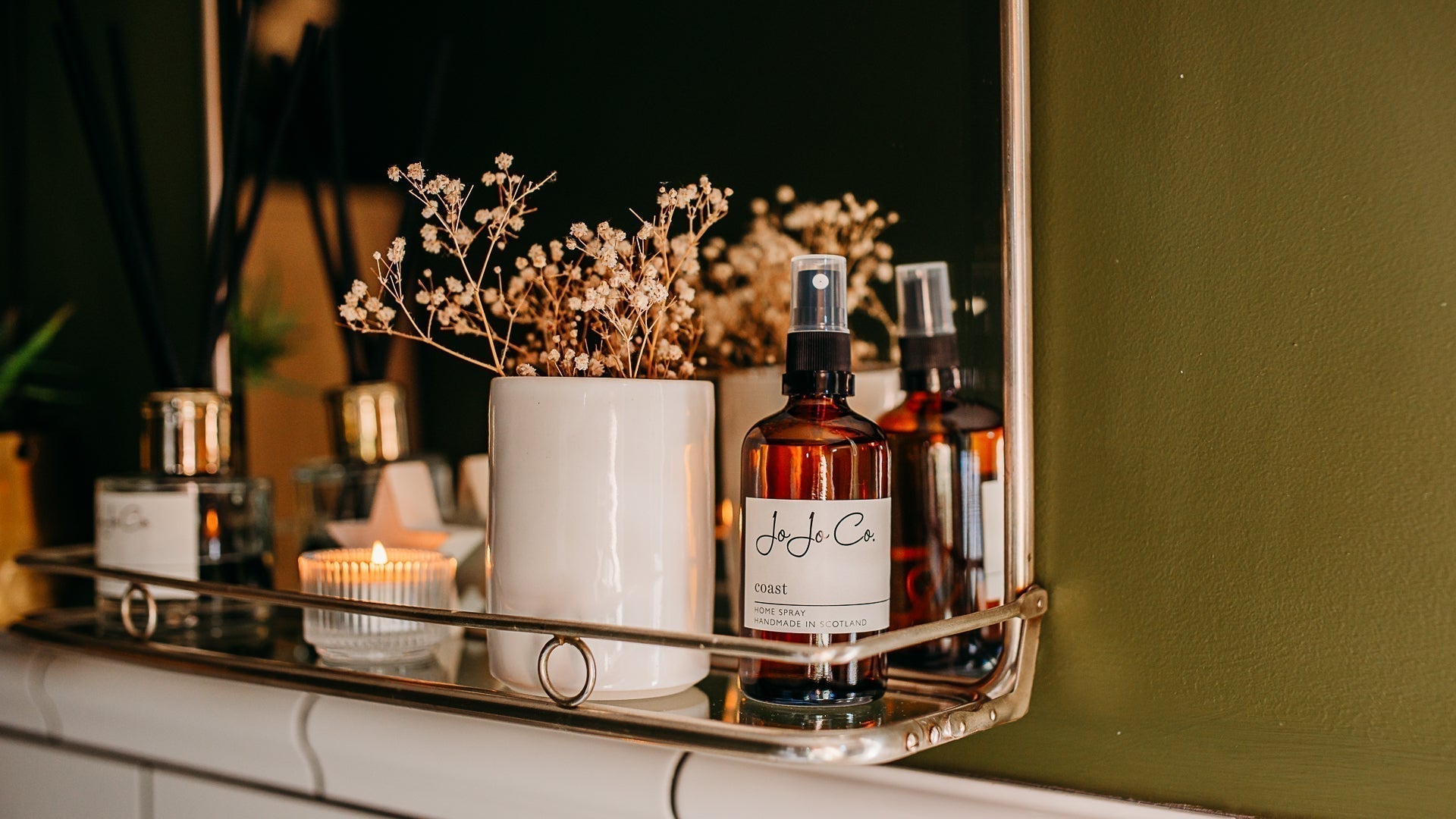 Luxury home fragrance products including candles, diffusers and room sprays styled in a fresh modern home to create a beautifully scented space.