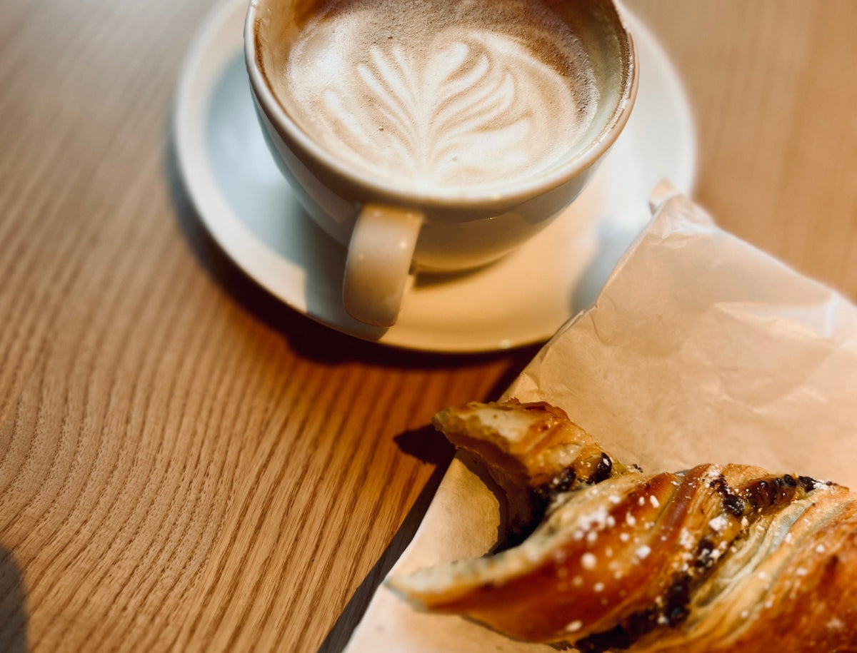 Coffee and pastry on a wooden table – enjoying the little everyday moments