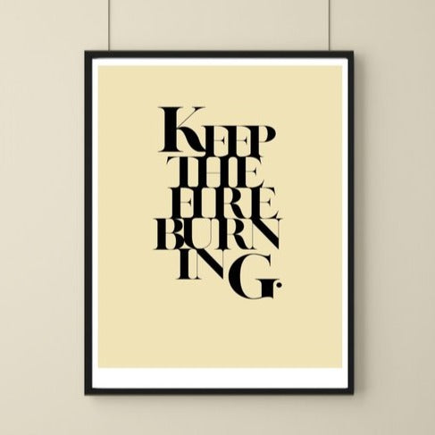 A simple art print with solid cream background and the words keep the fire burning written on it