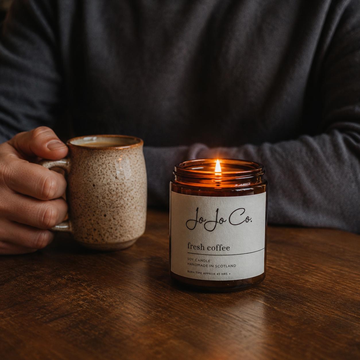 A man holding a coffee cup beside a luxury handmade coffee scented candle by JoJo Co, styled as a thoughtful Father’s Day gift for dads, grandads and father figures. 