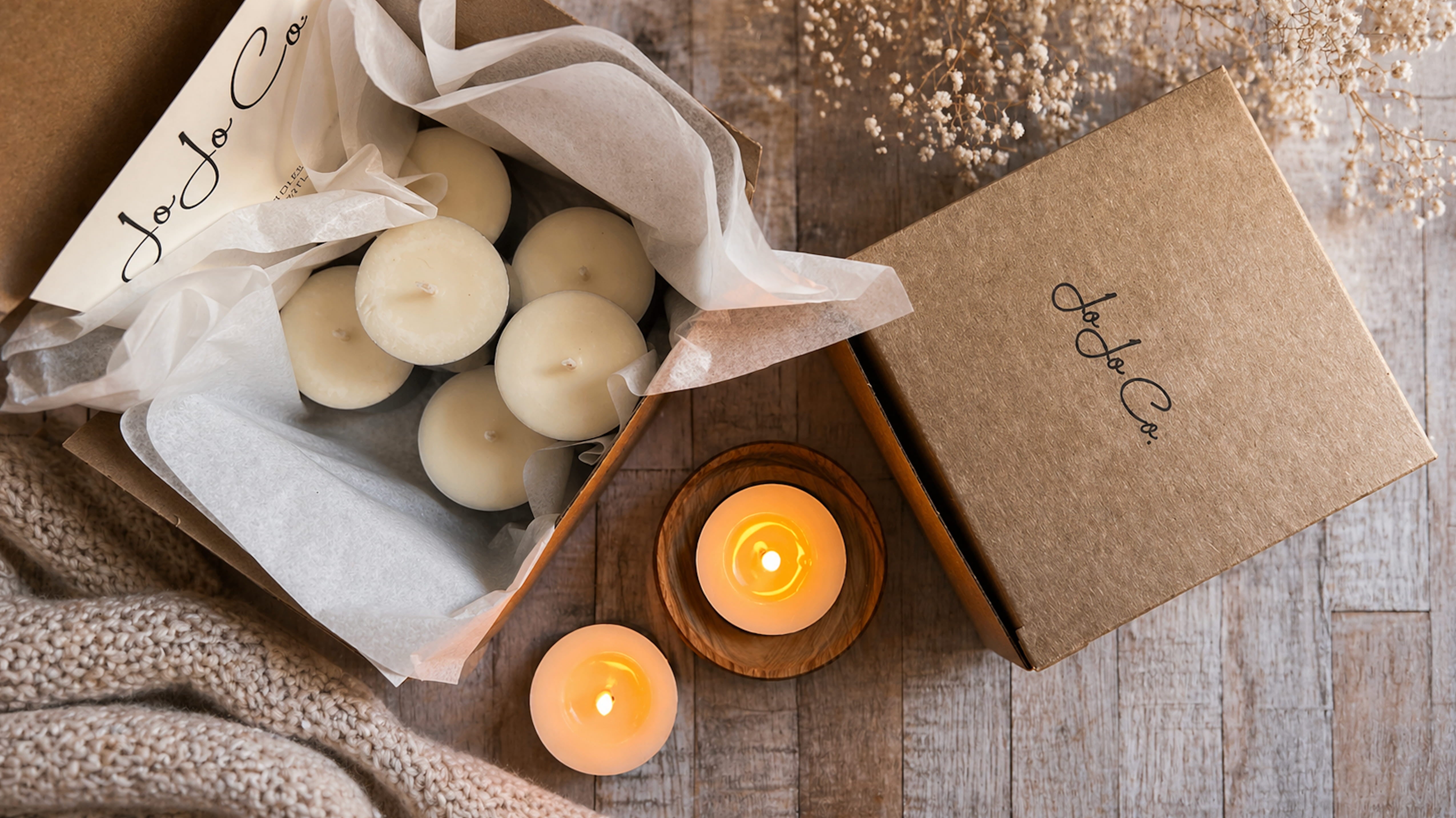 A luxury candle scent discovery box with tealights displayed in a cosy home setting, designed to help customers try different home fragrances before choosing a full-size candle 
