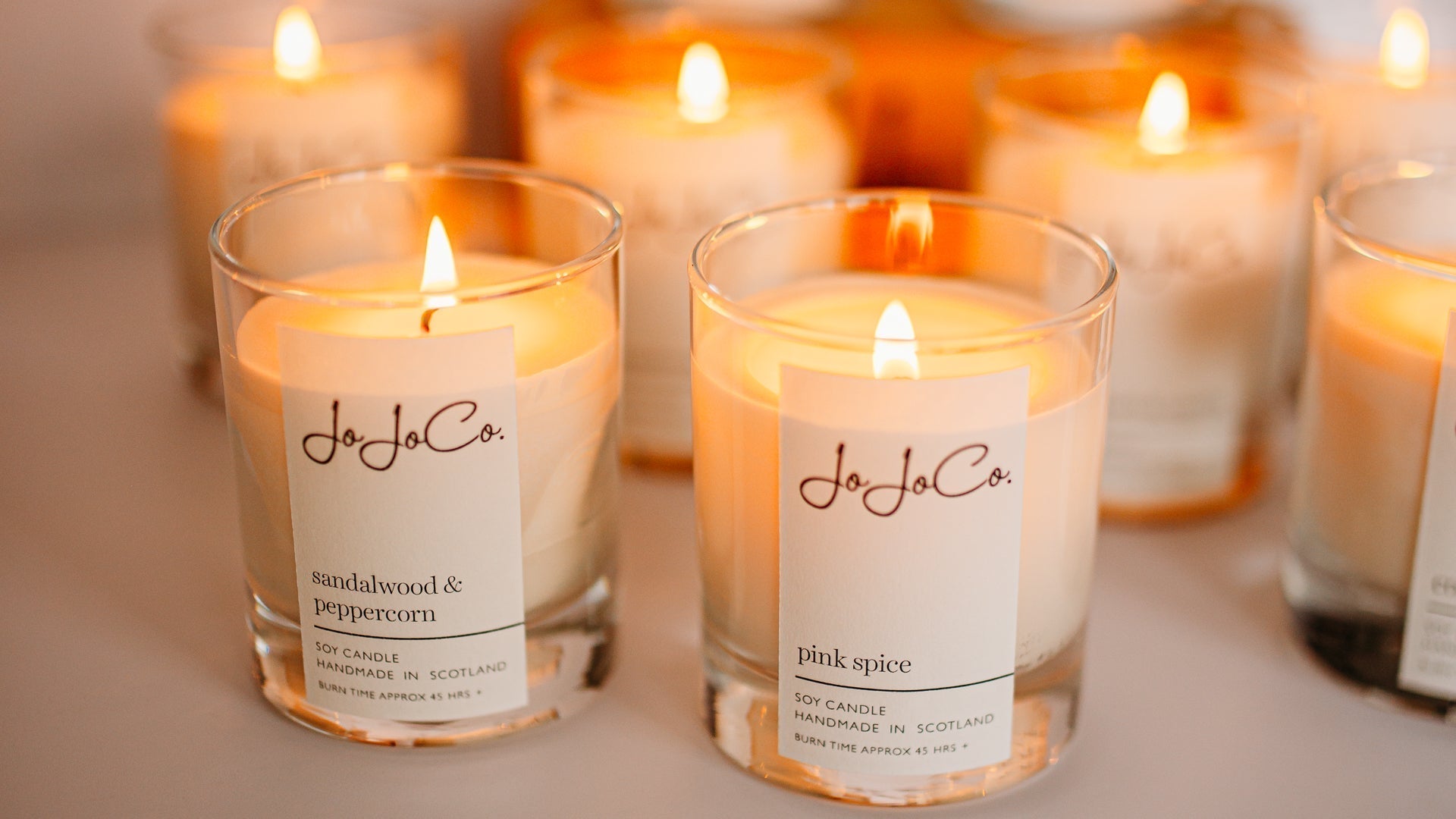A collection of lit luxury soy candles in different fragrances, showing how scented candles can be used throughout the home to create different moods in each room.