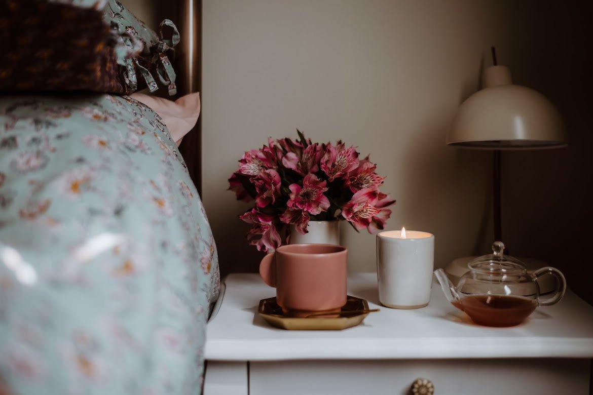 Cosy bedroom with fresh bedding and JoJo Co. scented candle creating a relaxing evening atmosphere 
