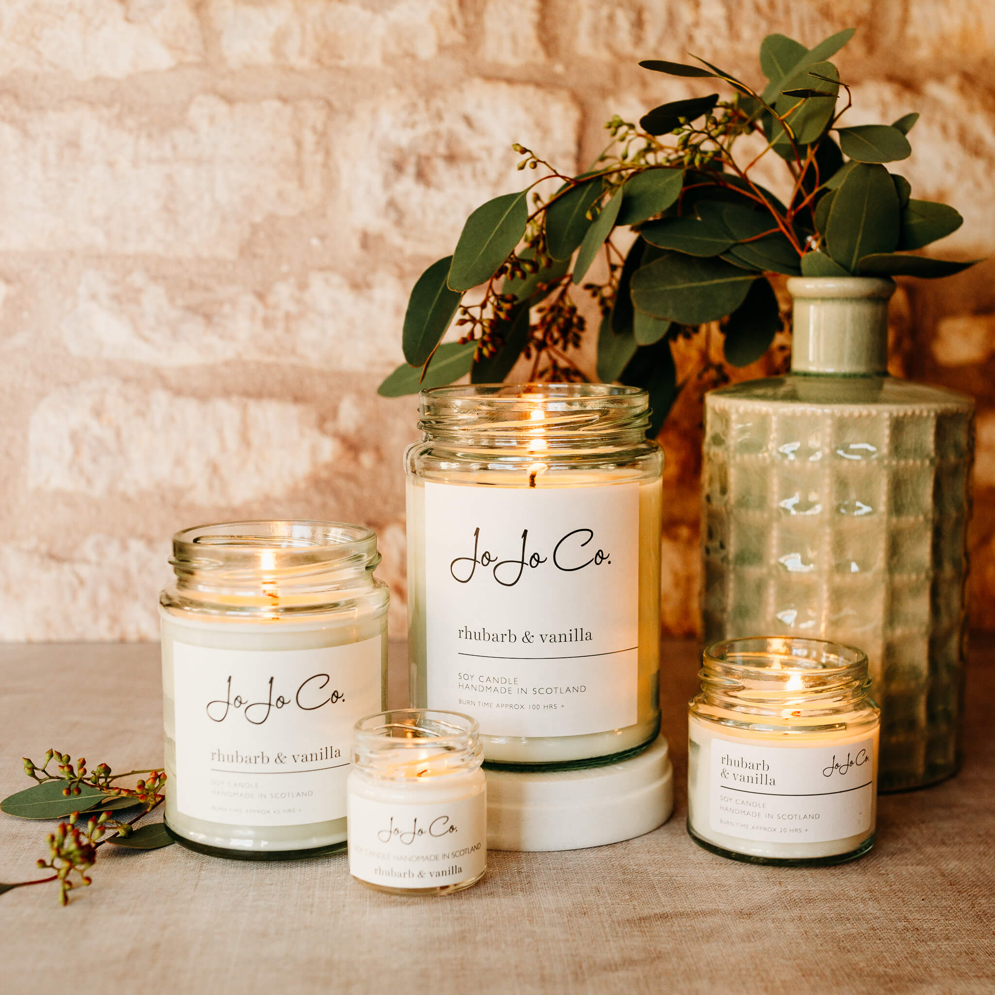 A group of JoJo Co Rhubarb Vanilla Candles in a variety of sizes