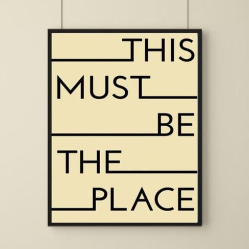 A simple art print with solid cream background and the words this must be the place on it